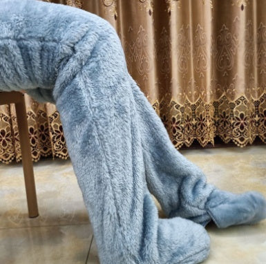 Blue fuzzy pants being worn, with a decorative curtain in the background.