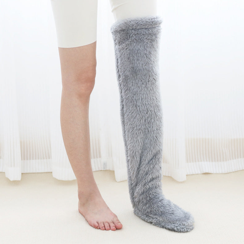Gray fuzzy knee-high socks worn by a person on a white background