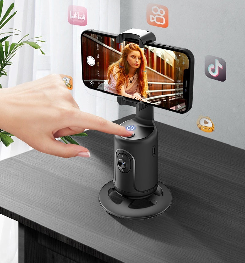 Hand using a smartphone with a gimbal on a desk, with social media app icons in the background. live stream vlogging camera holder